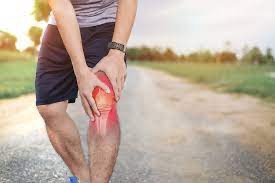 Holding knee inflamed with muscles and joints highlighted in red.