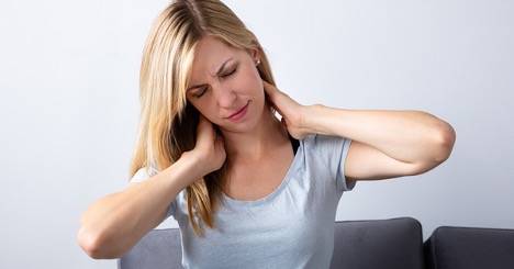 Woman holding her neck with both hands in pain.